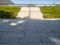 steps leading up to a building on the side of a building with a green field