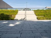 steps leading up to a building on the side of a building with a green field