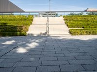 steps leading up to a building on the side of a building with a green field