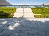 steps leading up to a building on the side of a building with a green field