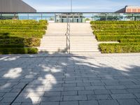 steps leading up to a building on the side of a building with a green field