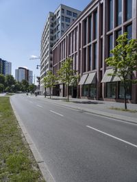 a deserted street with lots of windows and trees on the side of the road in front of it