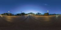 a view of an empty road at night time from the ground with low lighting on it