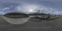 this is a fish eye view of the street bridge in a park with a river