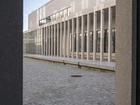 a woman in a blue suit is walking past a building that looks out into a distance