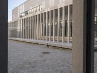 a woman in a blue suit is walking past a building that looks out into a distance