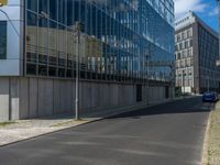 the street is quiet in front of a large glassy building with many windows and no one sitting on it