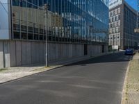 the street is quiet in front of a large glassy building with many windows and no one sitting on it