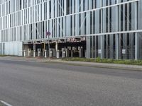 a man riding his skateboard down a empty city street in front of a glass office building