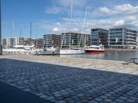 there are many boats that are parked on the water and in the city with buildings nearby