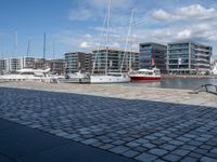 there are many boats that are parked on the water and in the city with buildings nearby