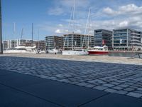 there are many boats that are parked on the water and in the city with buildings nearby