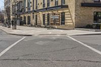 this is an image of city street intersection, with red stop sign and buildings in background