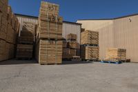 lots of wood are stacked in front of a building with a blue pallet full of wooden