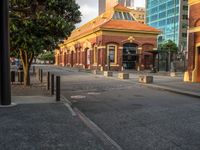 this photo shows a bus stop near an empty street and buildings on the side of the road