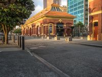 this photo shows a bus stop near an empty street and buildings on the side of the road