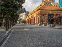 this photo shows a bus stop near an empty street and buildings on the side of the road