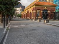 this photo shows a bus stop near an empty street and buildings on the side of the road