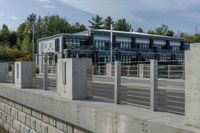 a long concrete fence is next to the building and street corner with multiple parked cars in it