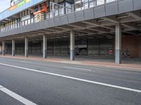 a bus is going by the side of a bus station and some cars are sitting nearby