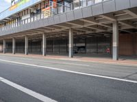 a bus is going by the side of a bus station and some cars are sitting nearby