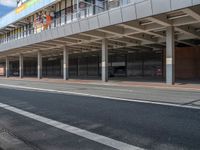 a bus is going by the side of a bus station and some cars are sitting nearby