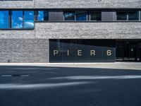 a large window in a building in front of a parking lot with the word pier 6 written on it