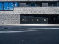 a large window in a building in front of a parking lot with the word pier 6 written on it