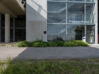 a building with windows is pictured by grass and a curb near it that says tropephherous