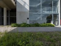 a building with windows is pictured by grass and a curb near it that says tropephherous