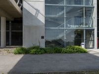 a building with windows is pictured by grass and a curb near it that says tropephherous