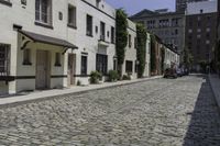 an image of a cobblestone path in the city of old town square with one bicycle and another car on the sidewalk