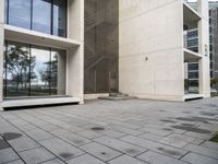 concrete blocks on a sidewalk with a glass entry door in front of a large building