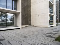 concrete blocks on a sidewalk with a glass entry door in front of a large building