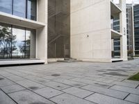 concrete blocks on a sidewalk with a glass entry door in front of a large building