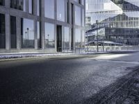 the shadow of a car is seen on the road near the building in the background