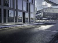 the shadow of a car is seen on the road near the building in the background