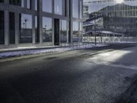 the shadow of a car is seen on the road near the building in the background