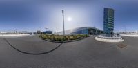 this is the photo looking very fish eye lensed by a large building with an airport in the background