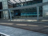 a man walking down a walkway next to tall buildings with glass walls and a walkway