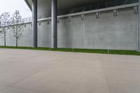 a cement floor in an open space with a fence around the corner and trees below