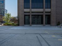 a street with a building near the building in the middle and on the left of which is a parking lot, as shown in this photo