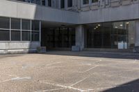 a person on a skate board riding across an empty walkway in front of a building