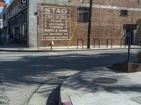 a store front and sidewalk with a fire hydrant next to it and a sign for stag