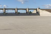 a person is riding their skate board on the concrete surface at the edge of a dam