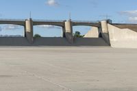 a person is riding their skate board on the concrete surface at the edge of a dam