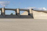 a person is riding their skate board on the concrete surface at the edge of a dam