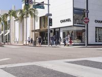 people are waiting at a crosswalk for a light to change on the street corner