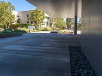 two grey blocks sitting next to a tall building on a sidewalk in front of grass