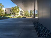 two grey blocks sitting next to a tall building on a sidewalk in front of grass